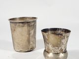 pair of silver cups on a white surface with a white background