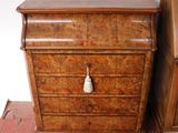 une petite commode en bois surmontée d'un pompon