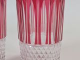 two red glasses sitting next to each other on a table