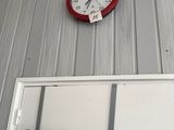 a clock on the wall above a door and a sign on the wall