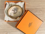 an orange box with a gold coin inside of it on a wooden surface