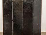 a black folding screen in the shape of a three - paneled room divider