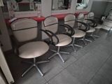 cinq fauteuils alignés en rang dans un salon de coiffure
