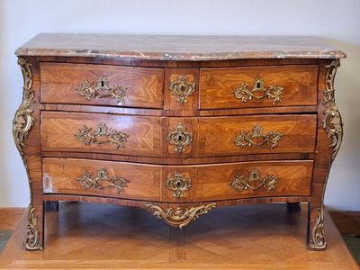 a wooden chest of drawers with a marble top