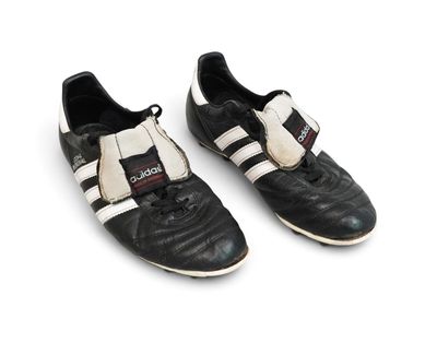 pair of black and white soccer shoes on a white surface