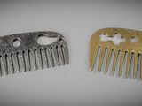 two pieces of metal hair combs sitting on top of a table