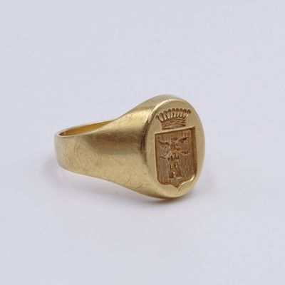 a close up of a gold signet ring with a coat of arms on it