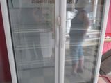 a white refrigerator with two glass doors in a room