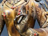 brass statue of a woman holding a bird on her arm