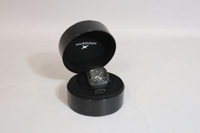 a black box with a watch inside of it on a white surface