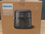 une friteuse à air chaud Philips dans son emballage, posée sur une table en bois