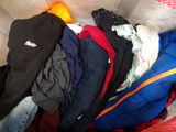 a pile of clothes in a basket on the floor