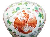 a white vase with a red and orange dragon on it