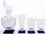 four glasses and a decanter sitting on a table