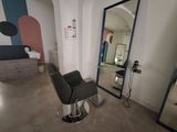 a black chair sitting in front of a mirror in a room