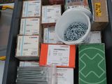 many boxes of screws and other items in a bin