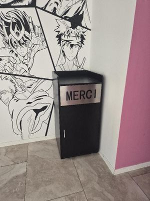 a black and white drawing on the wall next to a trash can