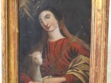 un vieux tableau représentant une femme tenant un chat, dans un cadre doré
