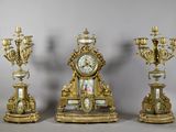 three gold and white clocks sitting next to each other on top of a table