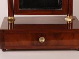 a small wooden clock with a mirror on top of it