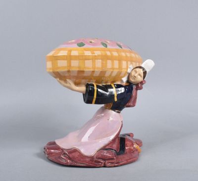 une figurine représentant une femme portant un panier sur la tête