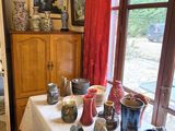a table with many vases on it in front of a window