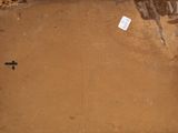 a brown piece of paper on the ground with a cross on it