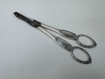 two pairs of scissors on a white surface