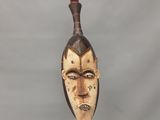 sculpture représentant la tête d'un homme avec un couteau qui lui sort de la bouche