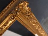 a mirror with a gold frame hanging on the wall