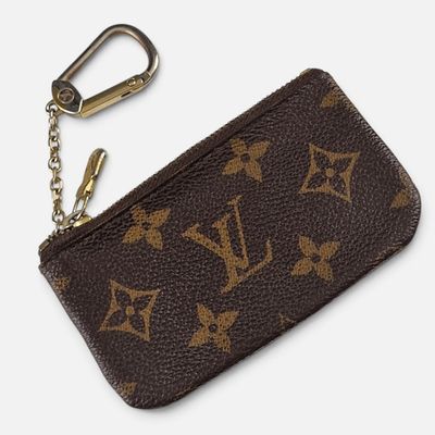 un gros plan sur un sac à main Louis Vuitton marron avec un porte-clés