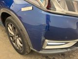 a close up of a blue car parked in a parking lot