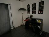 a room with a piano, a lamp, and pictures on the wall