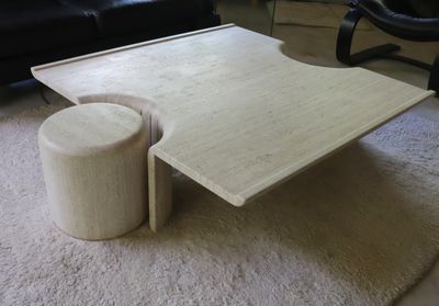 une table basse sur laquelle est posé un tabouret, dans un salon