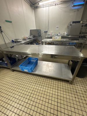 une grande table en acier inoxydable au milieu d'une cuisine