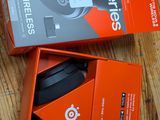 two boxes of headphones on a wooden table with a keyboard