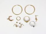 several pairs of gold and silver hoop earrings on a white surface