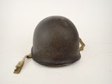 an old helmet is sitting on a white surface with a key in it