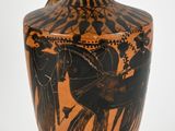 a black and orange vase with a picture of horses on it
