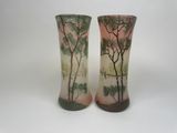 deux vases décorés d'arbres, posés sur une table