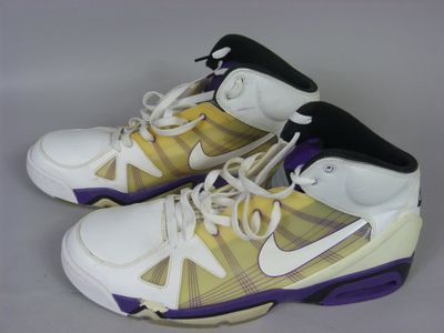 purple and white basketball shoes with purple accents on a gray surface