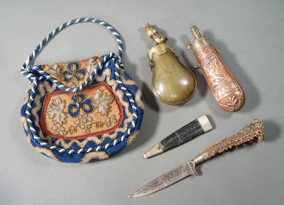 a purse with a handle, a knife, and other items on a table