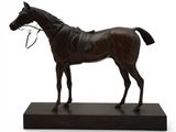 statue d'un cheval avec un mors, posée sur un socle noir