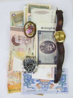 a lot of money and a watch sitting on a table