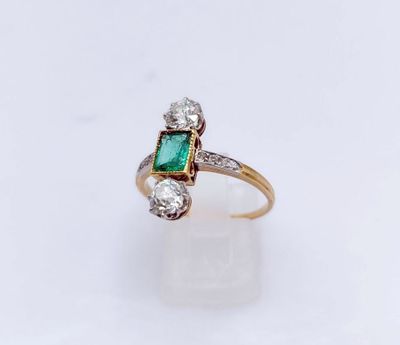 gros plan d'une bague avec une pierre verte et des diamants