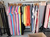 a lot of clothes hanging on a rack in a room