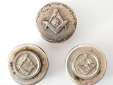 three antique silver buttons with masonic symbols on them on a white surface