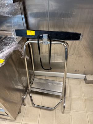 une cuisine en acier inoxydable avec un tabouret d'appoint en métal