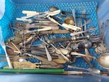 a blue basket filled with silverware and spoons