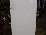 a white refrigerator in a garage with a bike in the background